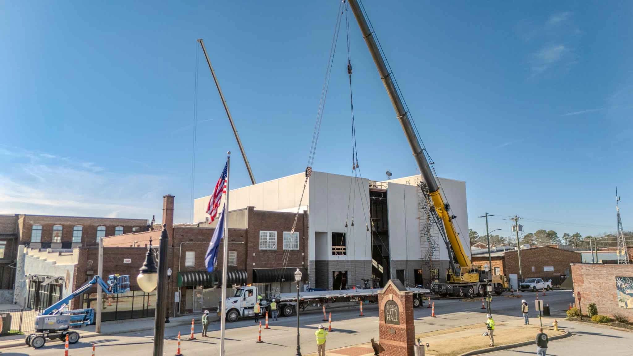 Cranes and construction crews working on the Seneca Center for the Arts beside City Hall.