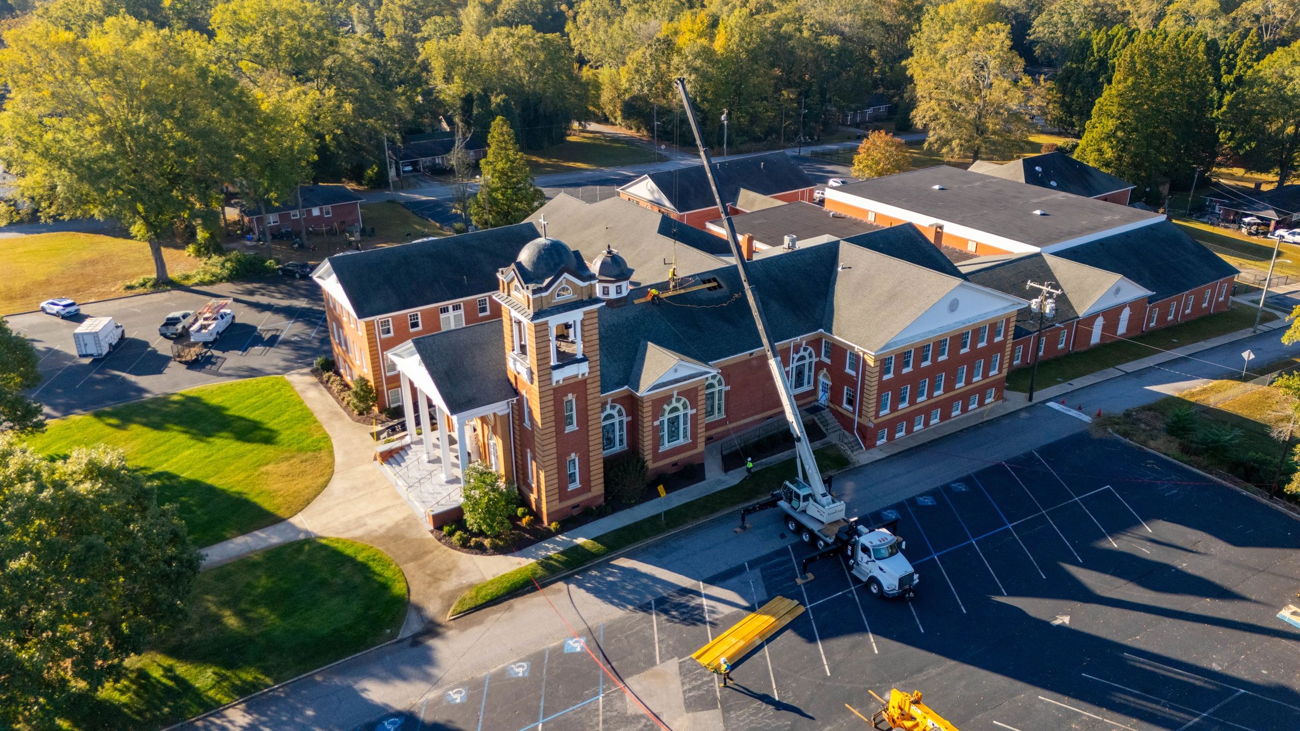 Aerial view of a crane lifting a beam over the roof of Belton First Baptist Church.