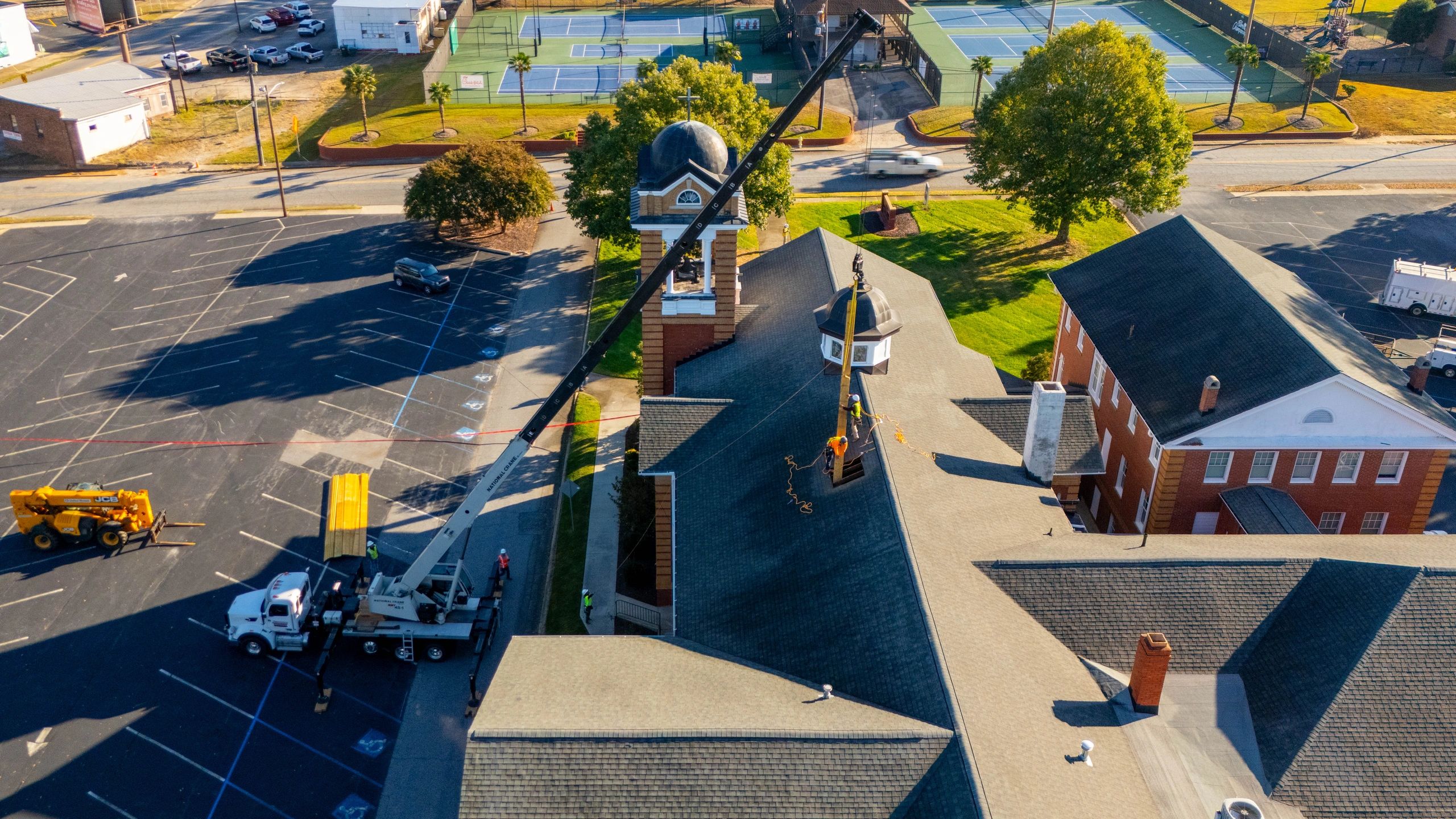 Drone photography of construction crew installing roof structure using crane in South Carolina