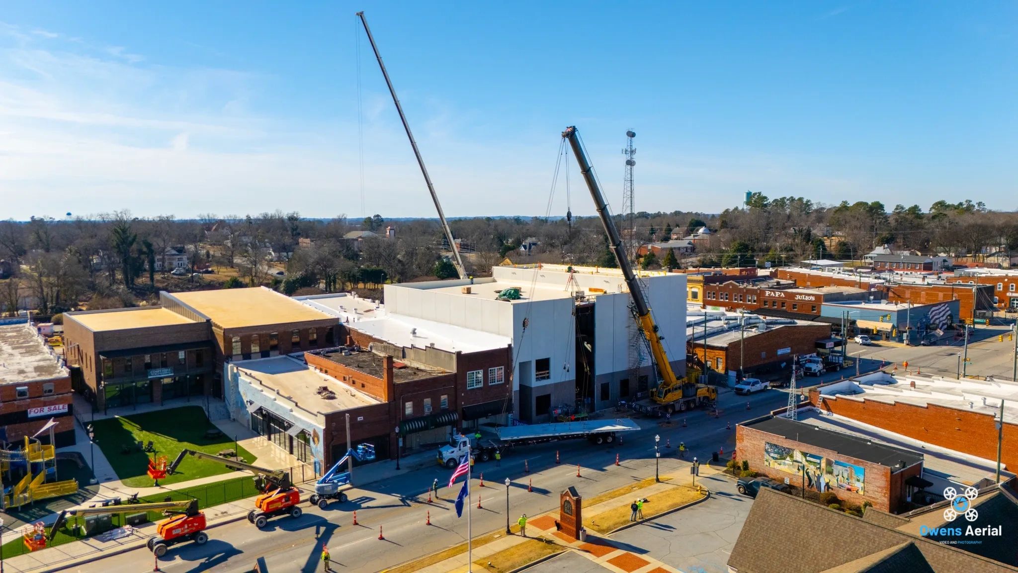 Cranes working on the Seneca Center for the Arts in downtown Seneca, with an Owens Aerial watermark.